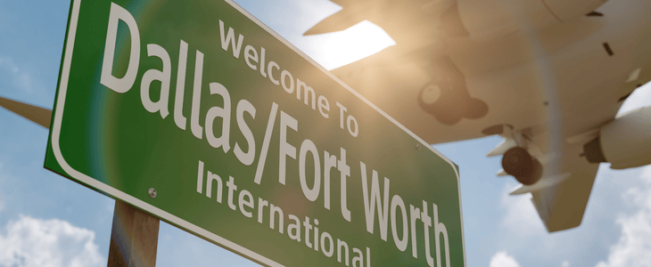 Plane flies over the welcome to Dallas sign